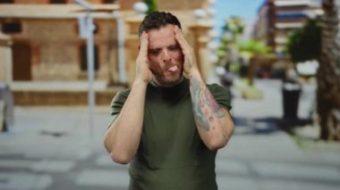 Dövmeli genç bir adam, şaşkın bir ifadeyle bir şehir sokağında gözlerini açar. Bir anlık neşe ve spontane bir anı yakalar..