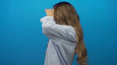 Çizgili tişört giyen kadın stüdyoda dürbünle el ele tutuşuyor..