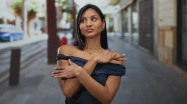 Kentsel sokak ortamında genç bir kadın, rahat bir ifadeyle gülümsüyor, kendine güveni ve zarafeti İspanyol ya da Latin amerikan özellikleriyle somutlaştırıyor..