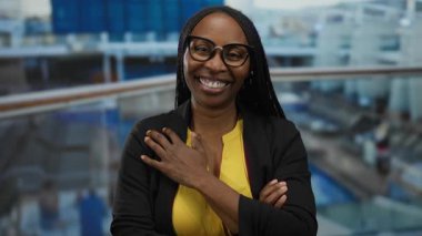 Deniz kenarındaki bir teknede gülümseyen bir kadın gözlüklü ve canlı bir atmosferi olan sarı gömlekli bir kadın limanda çekilen neşeli bir anı gösteriyor..