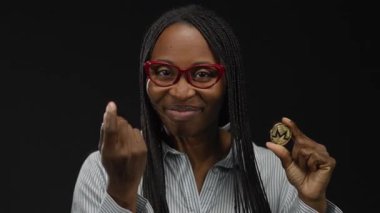 Monero sikkesini elinde tutan kadın, kara duvara karşı güvenli bir şekilde sanal para biriminin gücünü vurguluyor, kripto ve finansal güçlenmeye odaklanıyor..