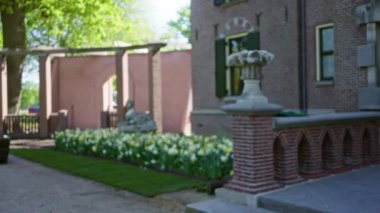 Bulanık bahçe manzarası, çözünmüş kale arkaplanı, dingin bir ortamda çiçek demeti ve eski tuğla mimarisi..