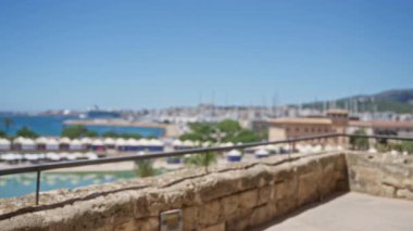 Açık mavi gökyüzü altında bulanık ufuk, taş duvar ve bokeh arkaplan ile Mallorca açık hava görüntüsünün odaklanmamış görünümü