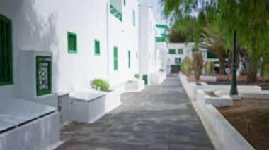 Lanzarote, kanarya adaları, İspanya 'daki yeşil aksanlı beyaz binalar, patikaları ve minimalist mimarisi olan güneşli manzaralar.
