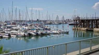 Torrevieja 'da güneşli bir marinaya yanaşan yelkenliler sakin bir deniz manzarası, canlı bir gökyüzü ve Cezayir, İspanya' da ahşap iskele, sakin bir açık deniz manzarası sergiliyor..