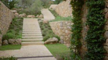 Akdeniz 'de taştan basamaklar ve yemyeşil yeşilliklerle dolu bulanık bir yol, sakin ve dingin bir eski dünya cazibesi yayıyor. Odaklanmış detaylar ve bokeh etkisi.