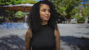 Yeşillik bir parka bakan bir kadın doğal güzelliğini sergileyen yeşil ağaçların arka planına işaret ederek Latin mirasını ve gençlik enerjisini vurguladı..