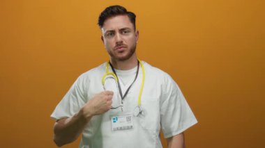 Turuncu bir duvarın üzerinden steteskop takan genç sakallı beyaz doktor kendine güvenerek profesyonel kimlik ve tıbbi uzmanlık gösteriyor..