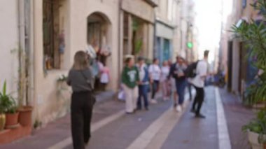 Marsilya, Fransa 'da dar bir cadde boyunca yürüyen odaksız insanlar, binalar ve bitkiler canlı bir şehir manzarası yaratıyor..