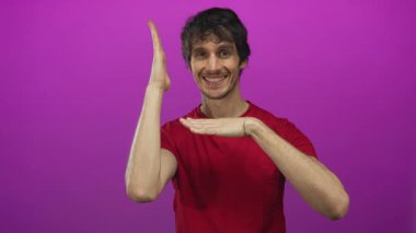 Kırmızı gömlekli genç adam stüdyoda mor arkaplan karşısında elleri ile çerçeve; yaratıcılık ilham sevinç.