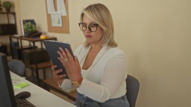 Ofiste parmakları ile tablet tutan ve ekranı tıklatan kadın; verimlilik verimliliği takım çalışması odaklı.