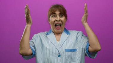 Elleri gözlerinin üzerinde olan bir kadın, onları kaldırır, ve şaşırır, canlı pembe bir arka plan karşısında, yaşlı bir İspanyol temizlikçi için neşeli, beklenmedik bir an yaşatıyor..