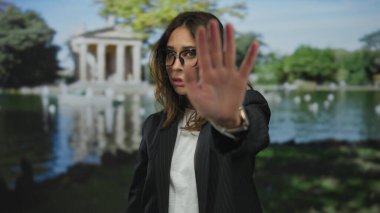 Parktaki kadın, el gözlüğü takarak reddediliyor ve arka planda tapınak zeminiyle güneşli bir ortamda açık havada seyrediyor. Dışarıdaki İspanyol kadını rastgele giyinmiş bir şekilde yakalıyor..