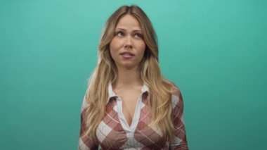 Uzun saçlı bir kadın profesyonel fotoğraf stüdyosu sahnesinde parmaklarıyla tırnak işareti yapıyor..