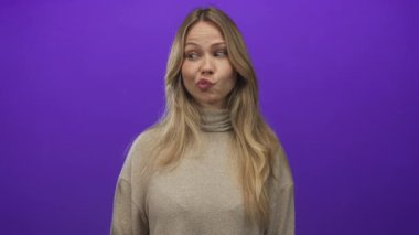 Dudakları büzüşmüş kadınlar balıkçı yaka kazak giyerek mor stüdyo kapanış portresi oturumunda; şakacı neşe kaprisli mizah.