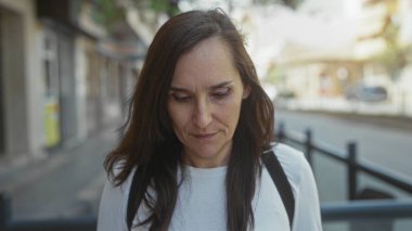 Bir şehir caddesinde sırt çantasıyla gülümseyen genç İspanyol kadın; mutluluk iyimserliği sevinç.