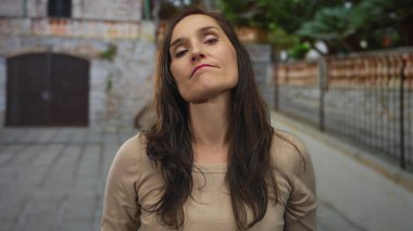 Dışarıdaki kadın kırsal bir ortamda el hareketleriyle hoşlanmadığını ifade ediyor, duygularını açıkça ifade ediyor..