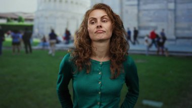 İtalya 'da Sidikli Kule' nin önünde poz veren, yeşil süveter giyen, şehir manzaralı arka planda turistleri barındıran bir kadın seyahat ve keşif önerisi sunuyor..