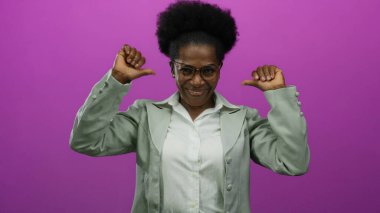 Kendine güvenen bir kadın, pembe bir arka plana, gözlüklü, gri ceketli, kendine güvenen ve profesyonelce davranan bir kadına dikkat çekiyor..