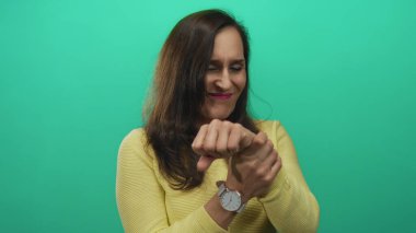 Bir video stüdyosunda yüzünü buruşturan ve bileğini tutmakta olan İspanyol genç bir kadın..