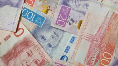 Krona para biriminin çeşitli değerlerde yer aldığı İsveç banknotları yayılarak, İsveç 'in finans sisteminden canlı renkler ve karmaşık tasarımlar vurgulanıyor.