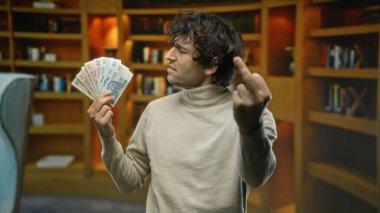 Kütüphanedeki İspanyol adam elinde Polonya parası ve kaba bir jest tutarak kitaplıklar arasında öfke ve hayal kırıklığını gösteriyor..
