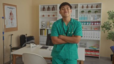 Tıbbi malzemelerle donatılmış yeşil önlüklü genç Çinli doktor klinik bir odada profesyonel ama rahat bir atmosfer sunuyor..