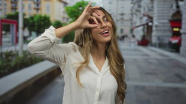 Kadın sokakta el ele işaret veriyor, güven onayı.