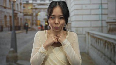 Sokak ortamında gülümseyen bir kadın, neşeli bir ifade sergiliyor, şehir ortamında açık havada..