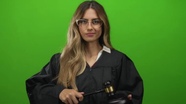 Siyah cüppeli kadın yargıç stüdyodaki tahta blokta tokmak vurdu..