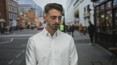 Kalabalık şehir sokağında gülümseyen bir adam önünden geçen arabalar ve vitrinlerle sıralanmış; mutluluk.