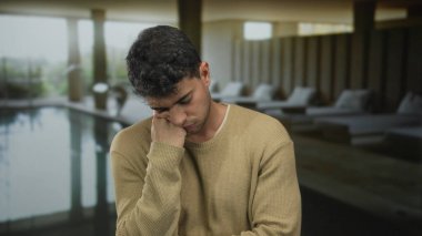 Adam spa salonunda esnerken elini dinlendiriyor. Yüzme havuzunda genç bir İspanyol erkek konuğun yanında kendini yorgun hissediyor..