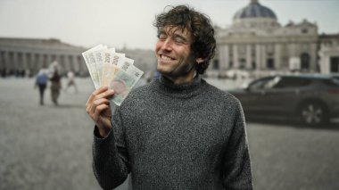 Aziz Peter Meydanı, Vatikan 'da gülümseyen ve elinde Czech Koruna banknotları tutan İspanyol bir adam açık hava atmosferinin ve ikonik mimarinin tadını çıkarıyor..