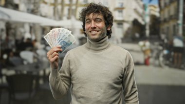 Cilalı şehir terasında elinde zloty banknotlar tutan adam finansal başarıyı ve açık hava yaşam tarzını yansıtıyor..