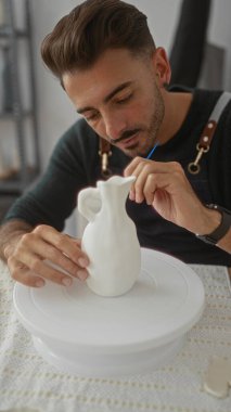 İnsan öne eğilir ve stüdyoda beyaz vazoyu tutarken heykel seramik formunu sabitler..