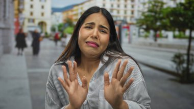 Şehir dışındaki hareketli bir sokakta duygularını ifade eden bir kadın. Geçmişi bulanık. Canlı bir ortamda şaşkın ve güvensiz duyguları somutlaştırıyor..