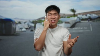 Şehir sokaklarında telefonla konuşan genç bir adam, etkileyici bir tavırla, canlı bir metropol ortamında iletişim ve şehir yaşamını vurguluyor..