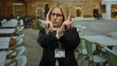 Kadınlar, restoranda elleri boş, masaları boş, iş kıyafetleri içinde gözlük takan ve kimlik kartı takan kadınlara el kol hareketi yapmazlar.