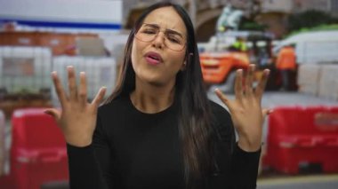 Bir inşaat sahnesinde, genç Latin asıllı Latin asıllı kadın duygularını bir forkliftin yakınındaki bir açık alanda ifade ederken, kadın hayal kırıklığına uğramış ifadesini sergiliyor..