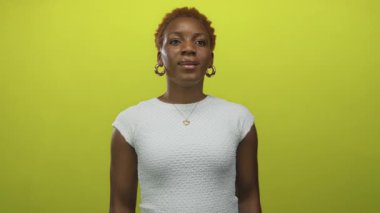 Genç Afro-Amerikalı kadın, parlak yeşil stüdyoda açık avuçlar ve açık ağızlar gösteriyor. Sürpriz..