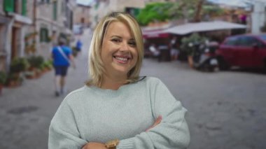 Kollarını kavuşturmuş ve kaşlarını kaldırmış bir kadın kentteki dar kaldırım taşı caddesinde dururken gülümsüyor; reddedilme inkâr şüphesi.