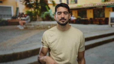 Bej gömlekli genç adam şehir sokaklarında hareketler yapıyor. Binaların ve insanların geçmişi bulanık. Canlı bir şehir atmosferi sergiliyor..