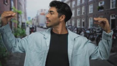 Tuğla binalar ve park edilmiş bisikletlerle çevrili hareketli şehir caddesinde el kol hareketi yapan adam, hevesli iletişim.