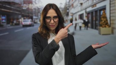 Gözlüklü genç İspanyol kadın kenar mahallede kendine güvenen bir şekilde poz verirken kenarı gösteriyor..