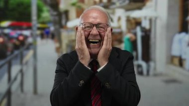 İş elbisesi giymiş yaşlı bir adam hareketli bir şehir caddesinde neşeli bir şehir geçmişi ve neşeli tavırları ile eğlencesini ifade ediyor..