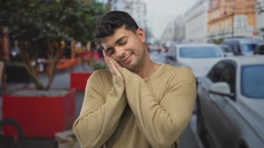 Erkek elleri yan yana hafifçe yanaklarında dinlenirken İspanyol genç açık hava rüyası gülen adam sakin görünüyor..