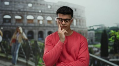 Roma 'daki tarihi Roma Kolezyumu' nun önünde tefekkür eden genç adam.