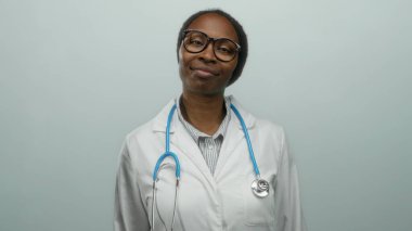 Steteskopla gülümseyen beyaz önlüklü bir kadın izole bir arka planda tıbbi profesyonelliği ve sağlık ortamında sıcaklığı somutlaştırıyor..