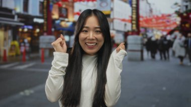 Dışarıdaki kalabalık bir sokakta gülümseyen kadın, şehir ortamında neşe ve enerjiyi yansıtıyor..