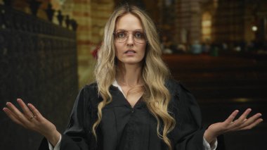 Kadın elleri dindar genç sarışın yargıç üniforması giyiyordu. Kilisenin içinde. Filmlerdeki törensel konuşmaların güçlü bir görüntüsünü oluşturuyordu..